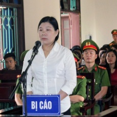 Vietnamese activist Tran Thi Xuan (C) stands during her trial in Ha Tinh province on April 12, 2018, where she was sentenced to nine years on charges of subversion, according to the state-run Vietnamnet news site. Three Vietnamese activists were jailed at separate trials on April 12 in the one-party state where a conservative leadership is accused of mounting an aggressive campaign against critics in recent months. / AFP PHOTO / Vietnam News Agency / Vietnam News Agency