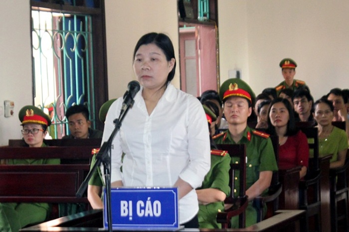 Vietnamese activist Tran Thi Xuan (C) stands during her trial in Ha Tinh province on April 12, 2018, where she was sentenced to nine years on charges of subversion, according to the state-run Vietnamnet news site. Three Vietnamese activists were jailed at separate trials on April 12 in the one-party state where a conservative leadership is accused of mounting an aggressive campaign against critics in recent months. / AFP PHOTO / Vietnam News Agency / Vietnam News Agency